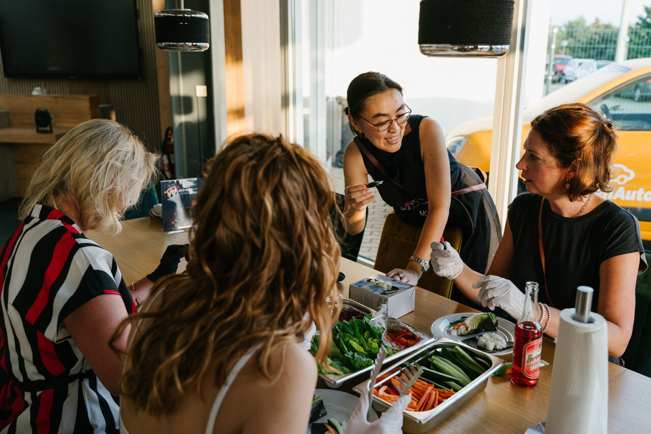 Das Bild zeigt vier weibliche Personen, die gerade Sushi machen.